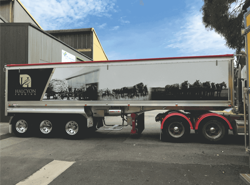 A semi's trailer has a large format black and white (photo) digital sign applied to both sides